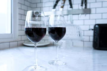 Red wine  in the glass In the modern kitchen . Classic white wall background .