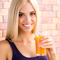 Beautiful blond woman drinking orange juice