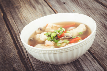 dumpling soup with green onion on wood table