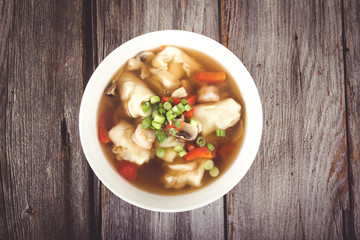dumpling soup with green onion on wood table