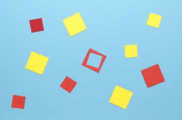 red and yellow squares of paper on a blue background