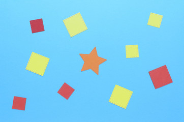 squares of paper and an orange star in the center on a blue background