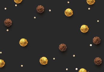Candies chocolate round in gold foil on dark background.