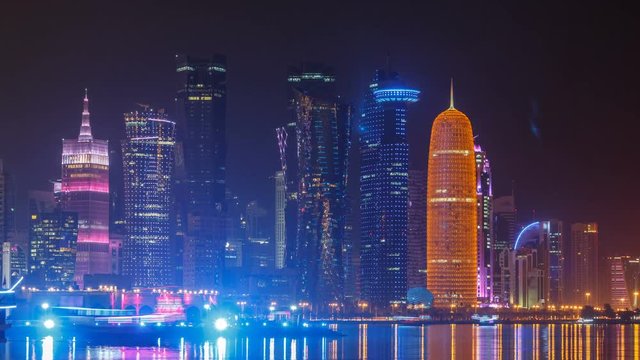 Traditional dhow boat in Doha at night timelapse, with modern buildings in the background.