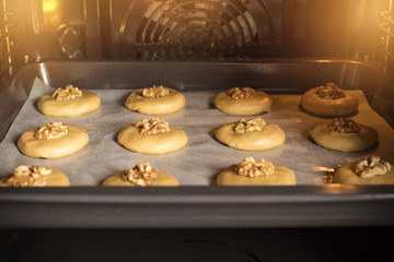 Raw honey biscuits with walnuts in the oven on a baking sheet with parchment paper, ready for baking. home cooking 1