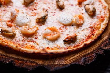Appetizing seafood pizza with shrimps and mussels, close up. Delicious Italian food
