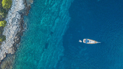 Fototapeta na wymiar Aerial view of anchoring yacht next to the island.