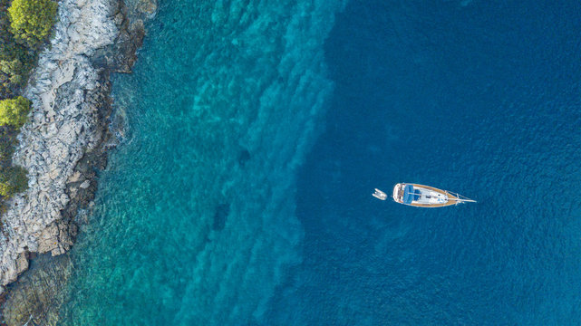 Aerial view of anchoring yacht next to the island.