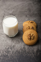 Honey biscuits with a core of walnuts on a white plate. Biscuits with powdered sugar. Dark background