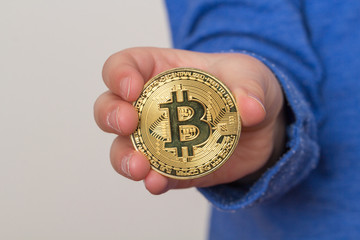 Kind hält eine Bitcoin Münze