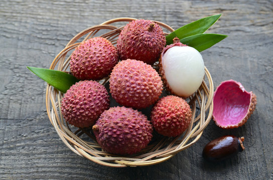 Fresh organic lychees in a basket on old wooden background.Exotic tropical lychee fruits.Raw diet or vegan food concept.Selective focus.