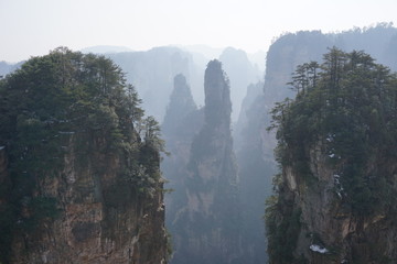 Mountains in China with trees and dust in sunshine