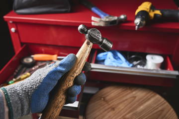 a worker holding a wood and steel hammer.