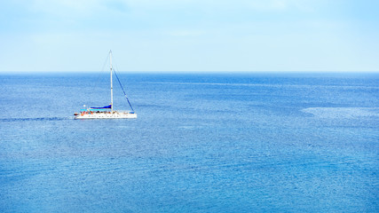 Obraz premium A sailing yacht sails in middle of sea