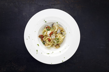 Spaghetti alle vongole with tomato pesto as top view on a plate