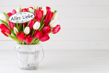 Springt time. Red tulip bouquet on the white wooden background.