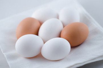 Chicken white and brown eggs on the napkin