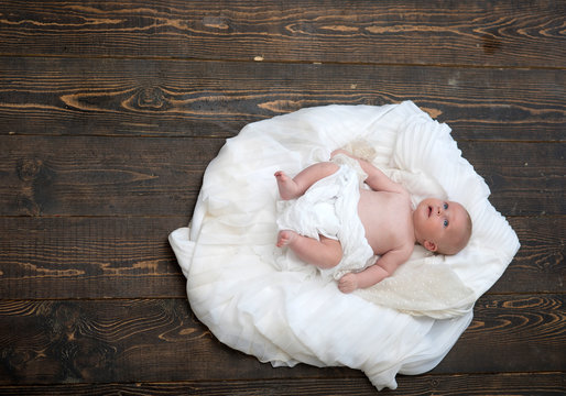 Childhood and Divine gift concept. Infant covered with white duvet.