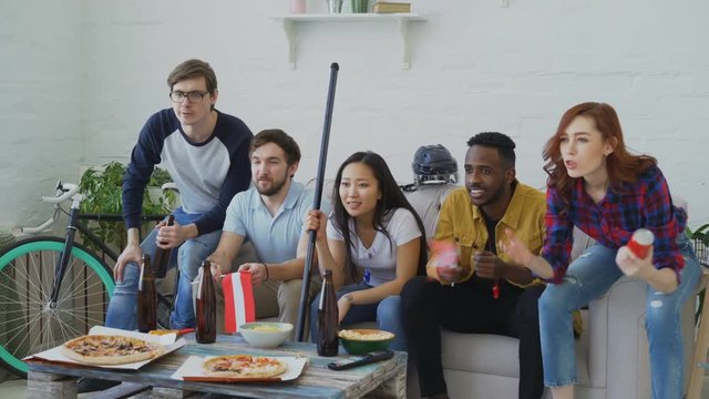 Multi ethnic group of friends sports fans with Austrian national flags watching hockey championship on TV together cheering up their favourite team at home