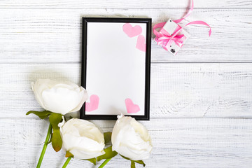 Empty dark frame decorated with pink hearts and white flowers