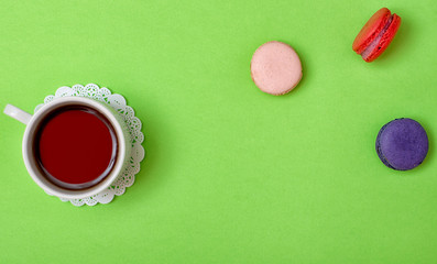 Colorful sweet macaroons and a cup of tea. Delicious breakfast. Top view.	