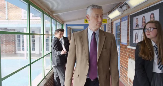 4K Strict teacher walking through school building & reprimanding student for messy uniform