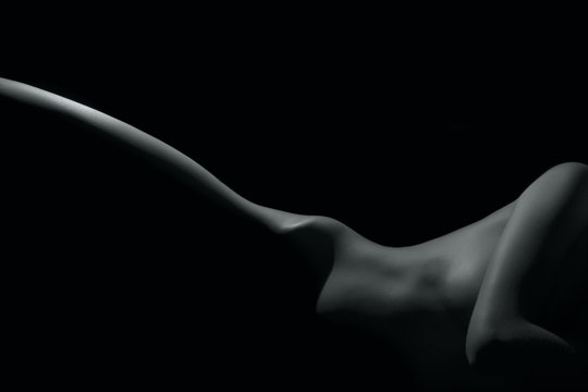 Silhouette of a body part , nude woman isolated on black background