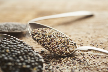white, brown and red quinoa seeds on retro silver spoon