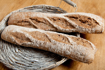 Fresh bread in a basket on a brown background