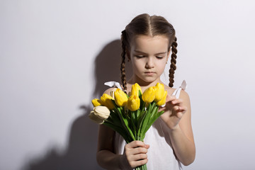 beautiful little girl caucasian with a bouquet of tulips