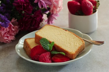 Sliced homemade butter pound cake served with strawberries, selective focus