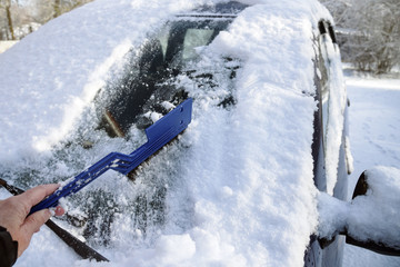 cleaning the car windshield from snow in winter, safety concept for traffic and transport, copy space