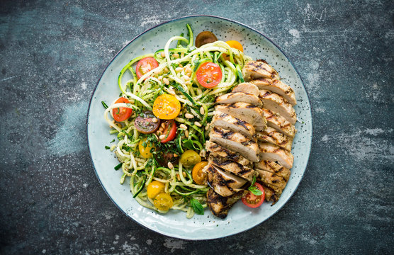 Grilled chicken with cucumber pasta, pine nuts and tomatoes