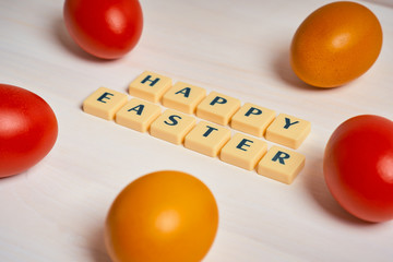 Easter decoration with colored eggs and text on a white wooden table
