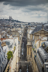 Fototapeta na wymiar View of Paris, Rue Saint-Roch with Sacre Coeur basilica in the background