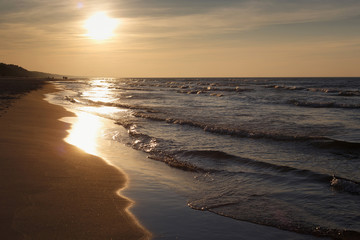 Beautiful sunset seascape on the with sun and small waves.