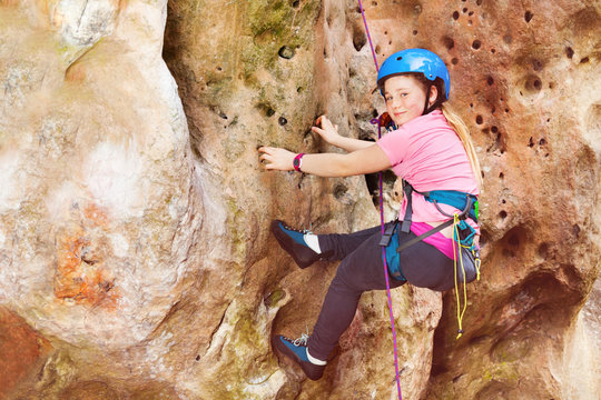 Teen girl rock climbing on a very difficult route