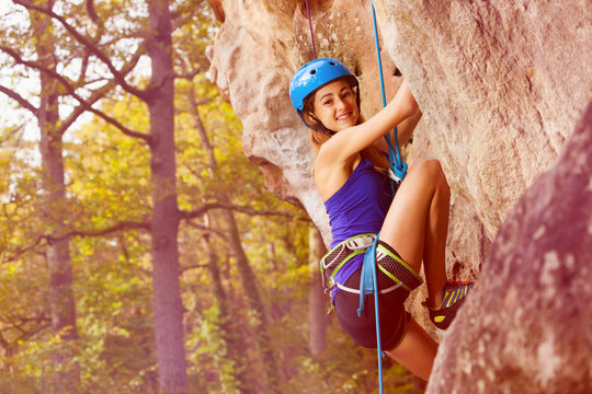 Female rock climber trying to climb the cliff