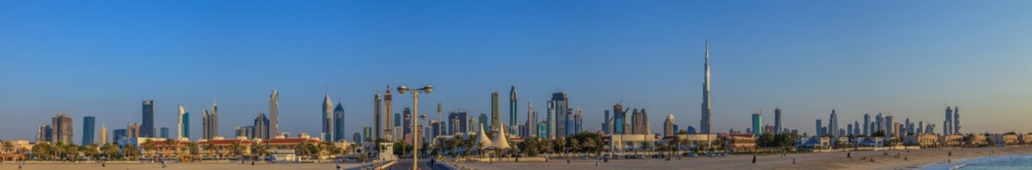 Panorama der Skyline von Dubai bei Tageslicht und blauem Himmel fotografiert von der Meerseite im...