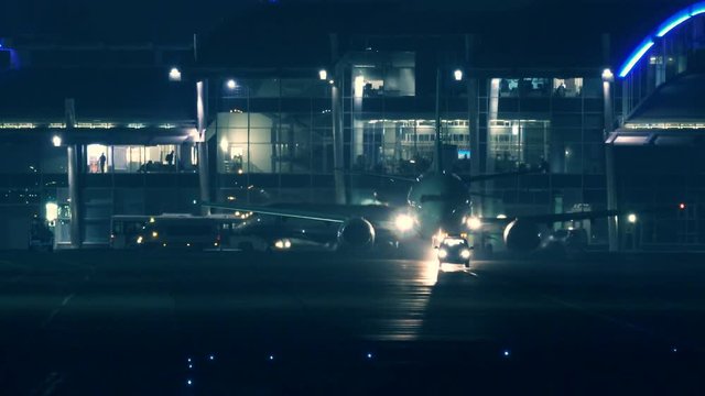 The plane with the escort car rides along the runway, preparing for take-off at night