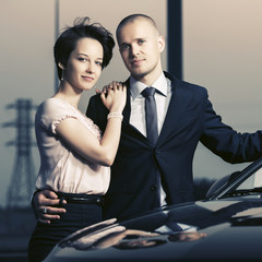 Happy young couple in love next to car