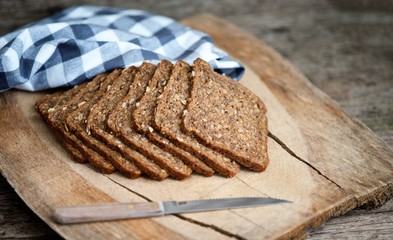 whole-grain rye bread with seeds on a weathering wooden board