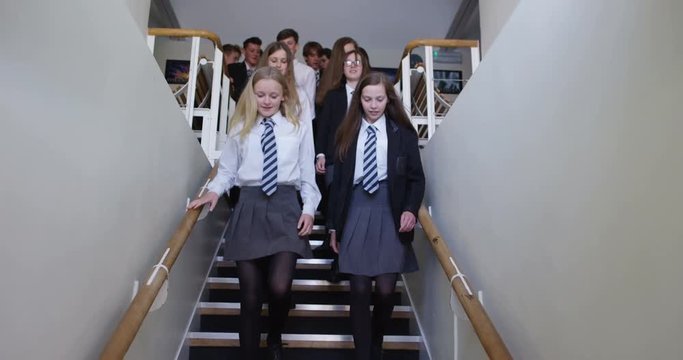 4K Tracking shot of happy students walking through school building, going home at end of day