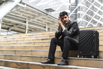 Business man sitting on stair with luggage in the routine of working with determination and confidence. concept of business trip travel and transportation.