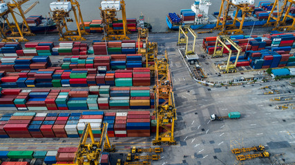 Logistics and transportation of Container Cargo ship and Cargo plane with working crane bridge in shipyard at sunrise, logistic import export and transport industry background