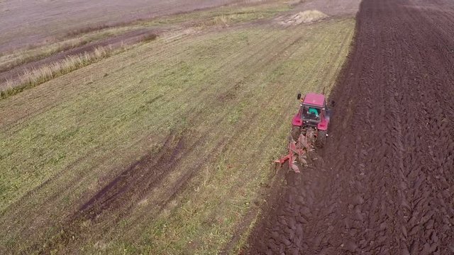 Plowing of pepper field on cloudy fall day. Aerial footage.