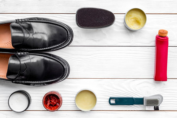 Plakat Shine shoes. Shoe care with polish, brushes, wax, sponge. White wooden background top view spacee for text