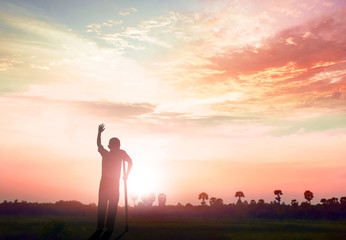  healing  concept: Silhouette a disabled man standing up at mountain sunset background