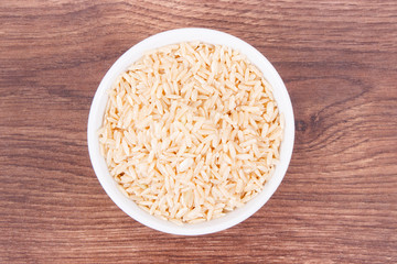 Heap of brown rice in glass bowl