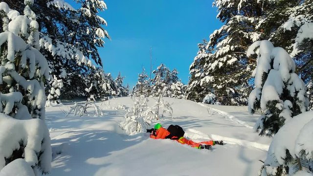 Photographer laying on a snow and taking photo